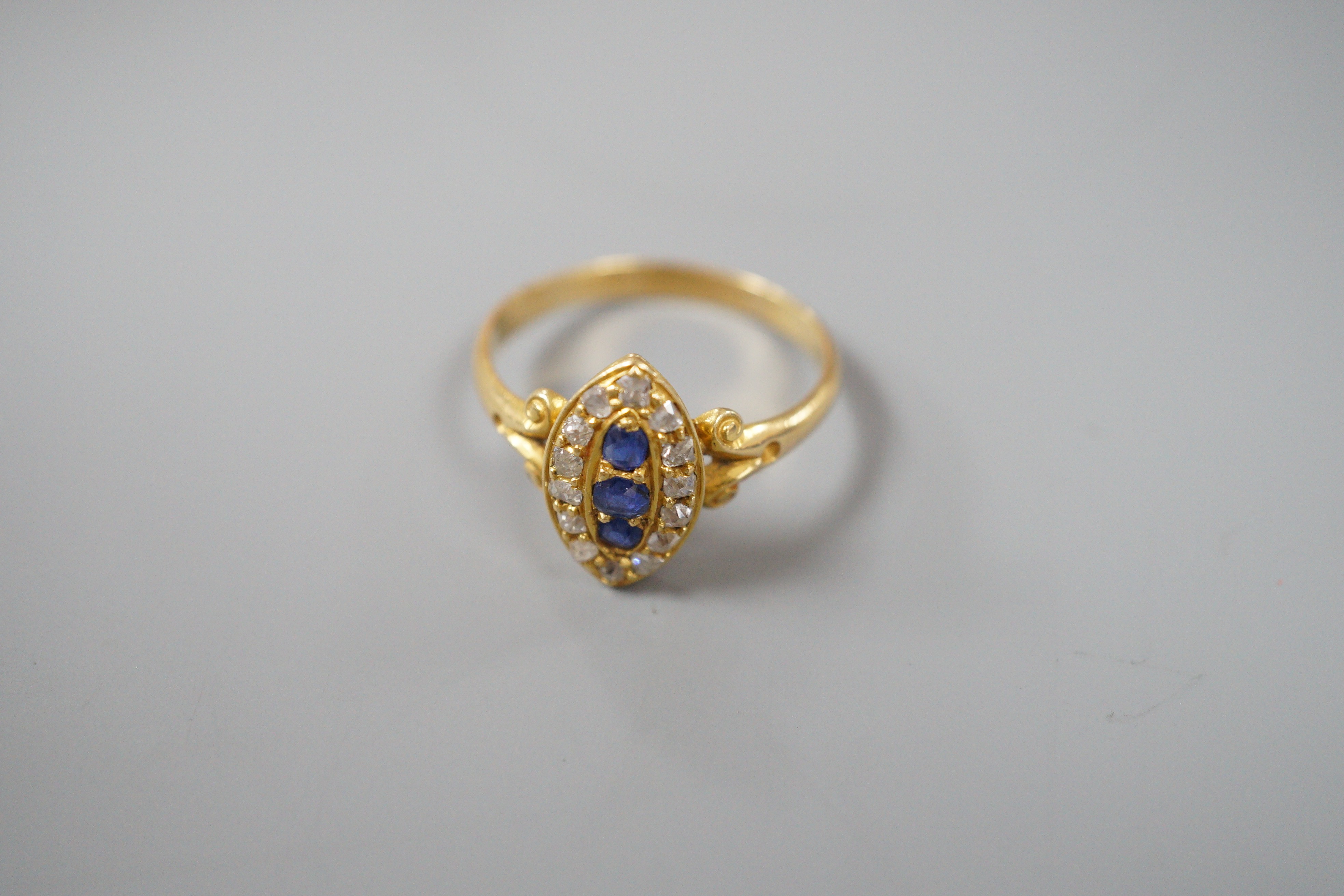 An early 20th century yellow metal, sapphire and diamond set marquise shaped cluster ring, with split shoulders, size R, gross weight 3.1 grams.